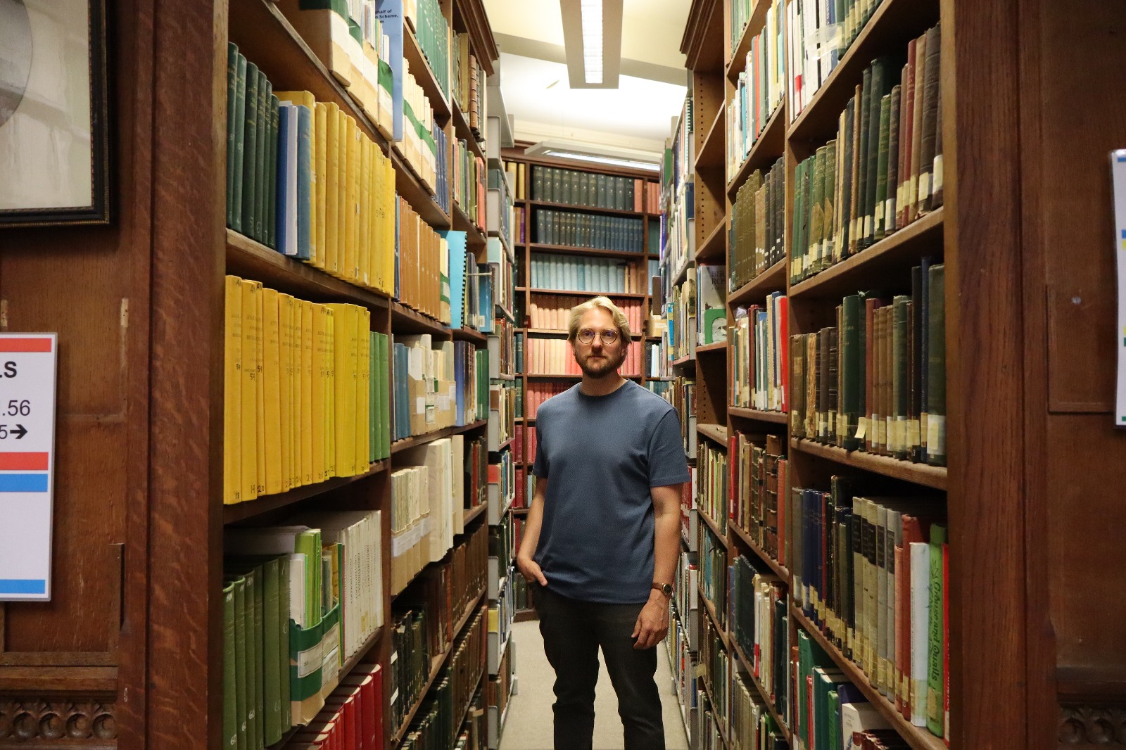 Sam Reynolds in the Zoology library during filming for ai@cam